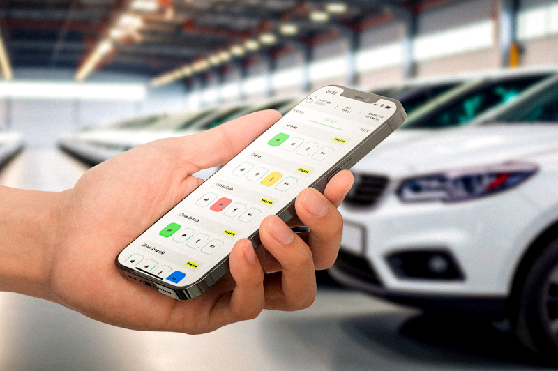 Pessoa segurando o aplicativo VEXSOFT em frente a uma garagem com carros de locadora