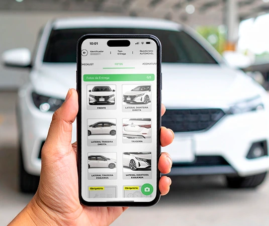 Pessoa segurando celular com o app VEXSOFT aberto, com carro ao fundo
